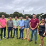 Deputado Moisemar Marinho e prefeito Nereu Fontes observam partida da 3ª Copa Society Ferrujão em Oliveira de Fátima, Tocantins, com jogadores em campo.