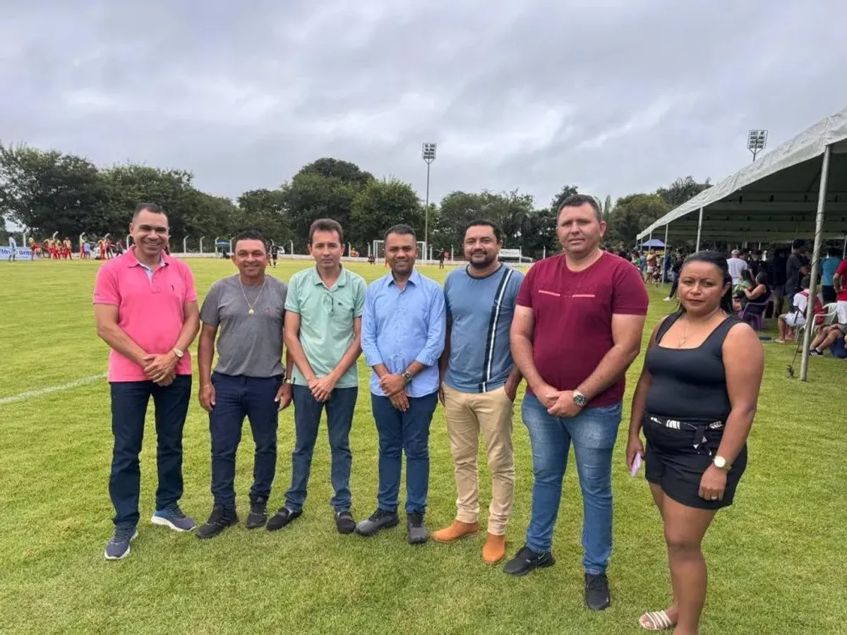 Deputado Moisemar Marinho e prefeito Nereu Fontes observam partida da 3ª Copa Society Ferrujão em Oliveira de Fátima, Tocantins, com jogadores em campo.